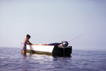 Ruth in a lake by a boat, c. 1950s